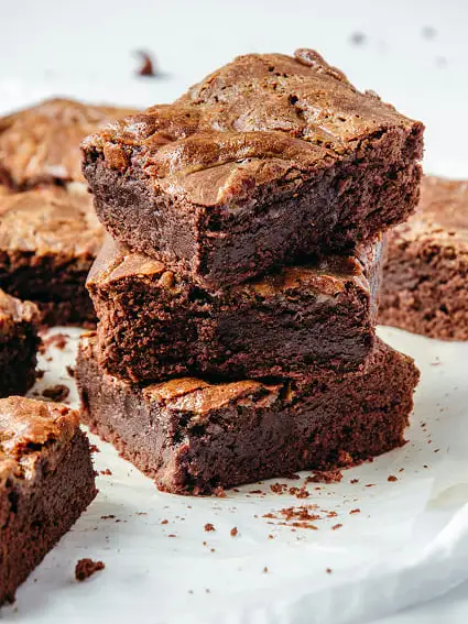 plato blanco con una torre de tres trozos de brownie