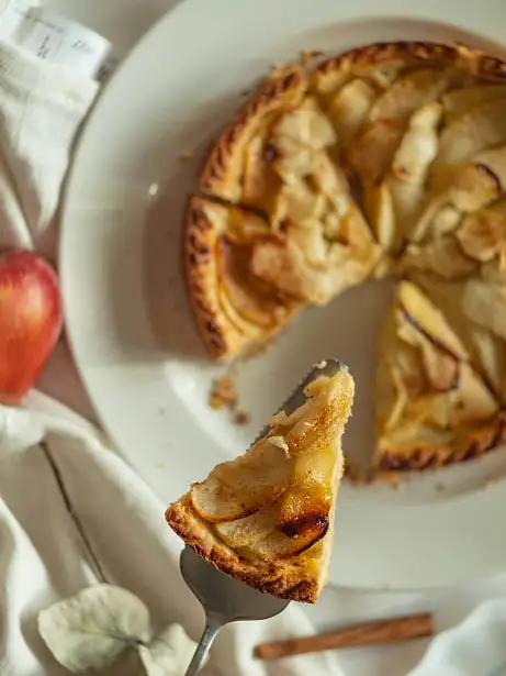 tarta de manzana con mermelada de albaricoque sobre un fondo de trapos blancos